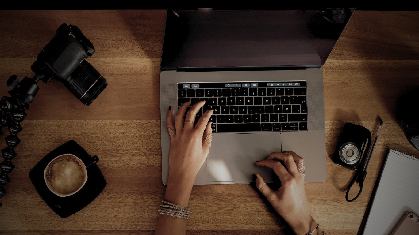 Person arbeitet am Laptop, von oben fotografiert, kreative Arbeitsatmosphäre